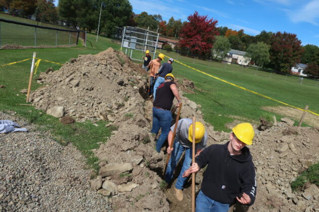 Students digging in building preparation of a new softball field