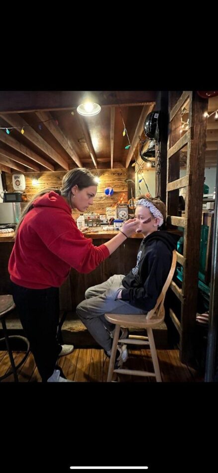 Profile view of student focusing on painting child's face